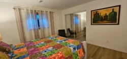 Bedroom with two windows and colourful quilt in the suite