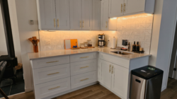 Bright kitchenette with white cabinets in the private vacation suite